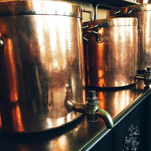 Massive copper cooking pots in the historic kitchens of Petworth House